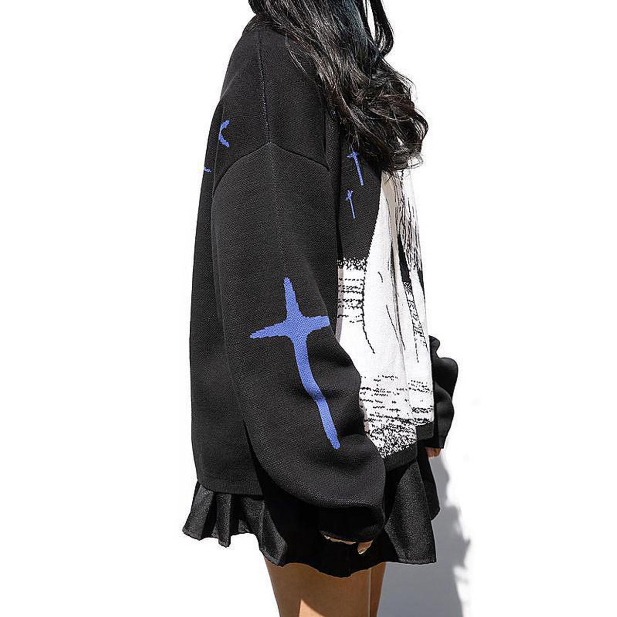 Women's printed pullover sweater with long sleeves, black with blue crosses and white graphic, side view on model