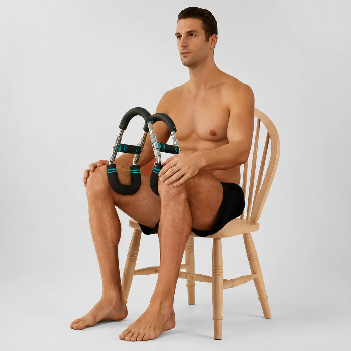 Multi-functional u-shaped arm strengthener black and teal model held by shirtless man sitting on wooden chair