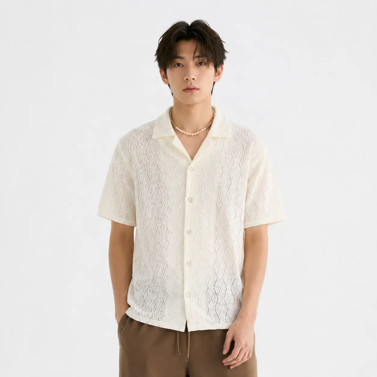 Vintage short-sleeve floral shirt for men, classic cardigan style in cream color worn by a model with pearl necklace.