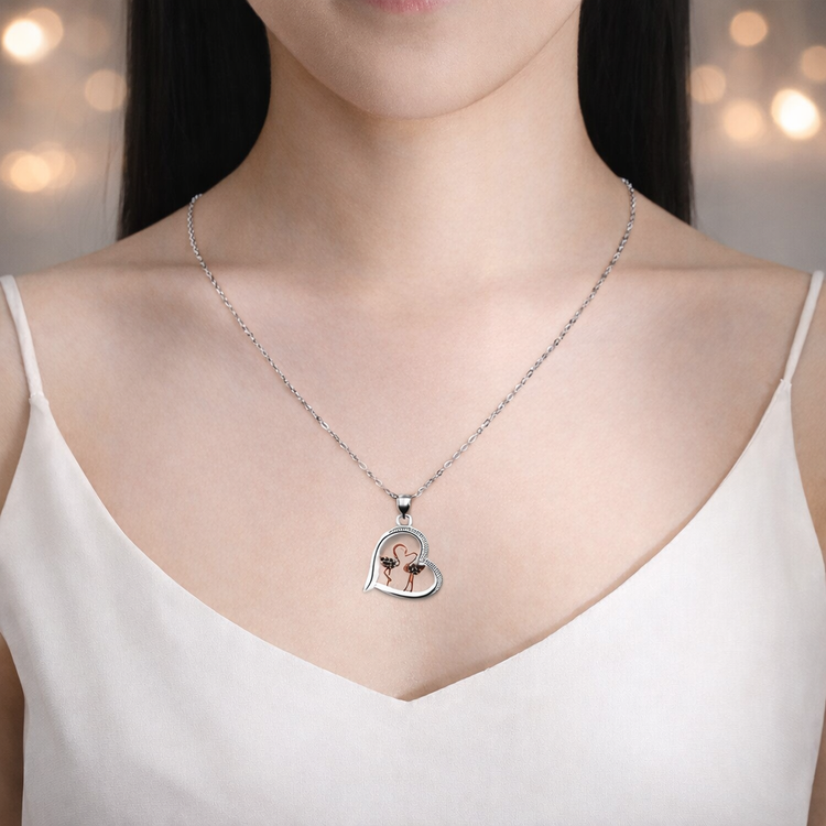 Person wearing a silver necklace with a heart-shaped pendant