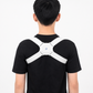 Person wearing a white posture corrector on a plain background