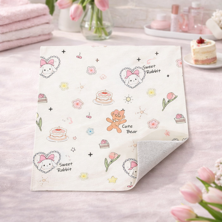 Baby blanket with cartoon designs on a pink surface