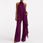 Purple jumpsuit worn by a model on a white background