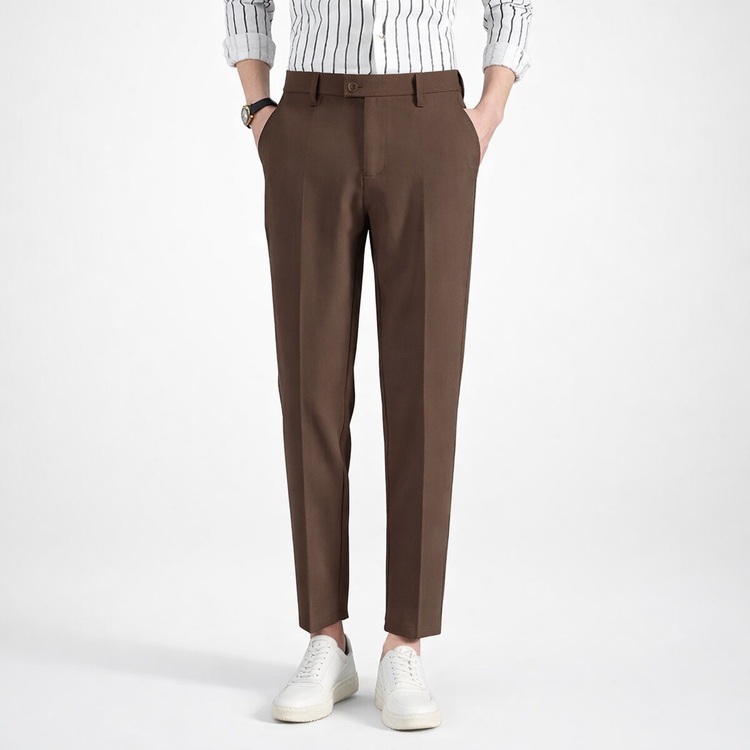 Brown pants worn with a white shirt and white sneakers on a white background