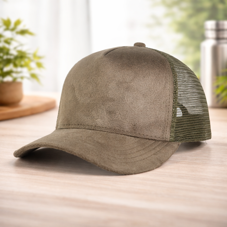 Brown suede cap with green mesh back on a wooden surface