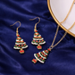 Christmas tree-themed jewelry set with earrings and necklace on a blue fabric background