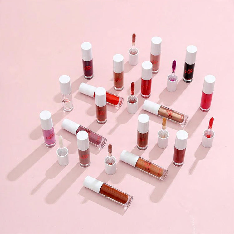 Collection of lip glosses on a pink background