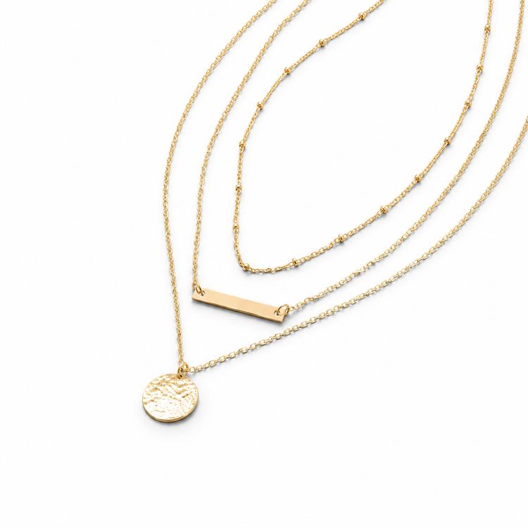 Three gold necklaces with different pendants on a white background