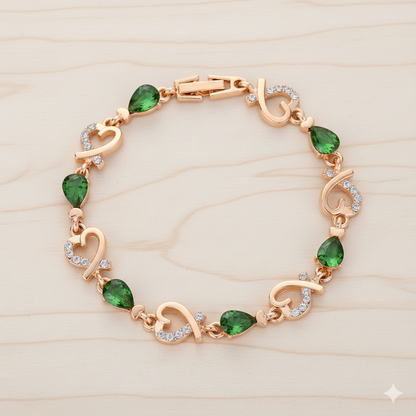 Gold bracelet with green gemstones on a light wood background