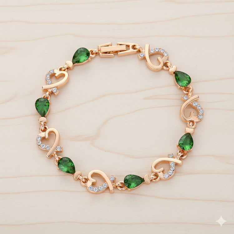 Gold bracelet with green gemstones on a light wood background