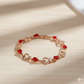 Gold bracelet with red gemstones on a beige background