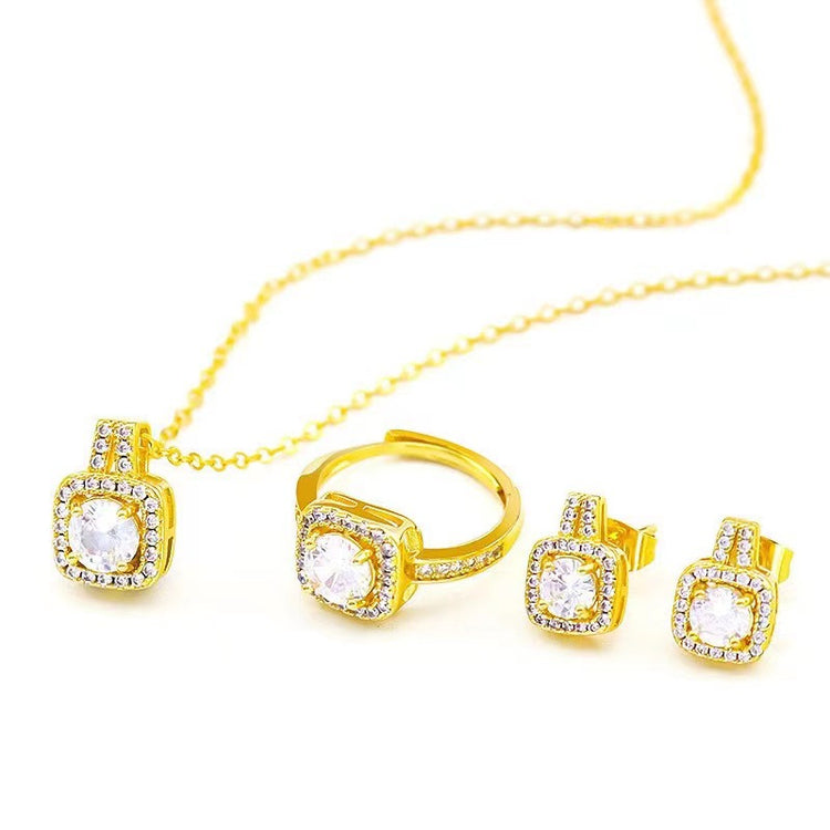Gold jewelry set with necklace, ring, and earrings on a white background