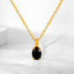 Gold necklace with a black gemstone pendant on a white background