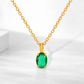 Gold necklace with a green gemstone pendant on a white background