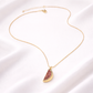 Gold necklace with a watermelon slice pendant on a white background