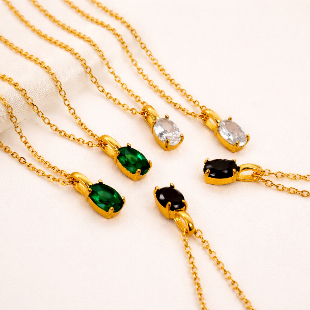 Gold necklaces with gemstone pendants on a beige background