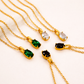 Gold necklaces with gemstone pendants on a beige background