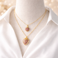 Gold necklaces with heart-shaped pendants on a mannequin wearing a white shirt.