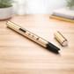 Gold pen with a black clip on a wooden surface