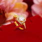 Gold ring with a diamond on a red surface