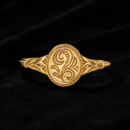 Gold ring with intricate design on a black background