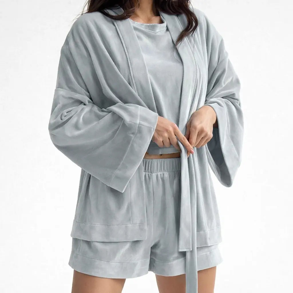 Three-piece pajama set for women in gray polyester worn by a model adjusting the robe tie.