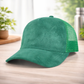 Green cap with mesh back on a wooden surface with a blurred background