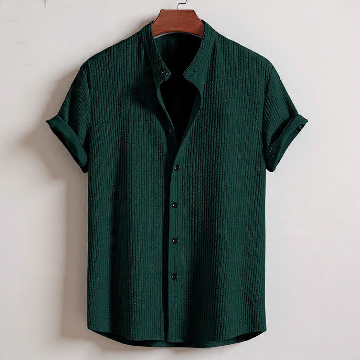 Green textured shirt on a hanger against a white background