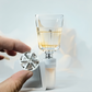 Hand holding a wine aerator with a glass of wine on a light background BLADE