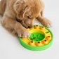 Dog playing with a green and yellow puzzle toy on a white background