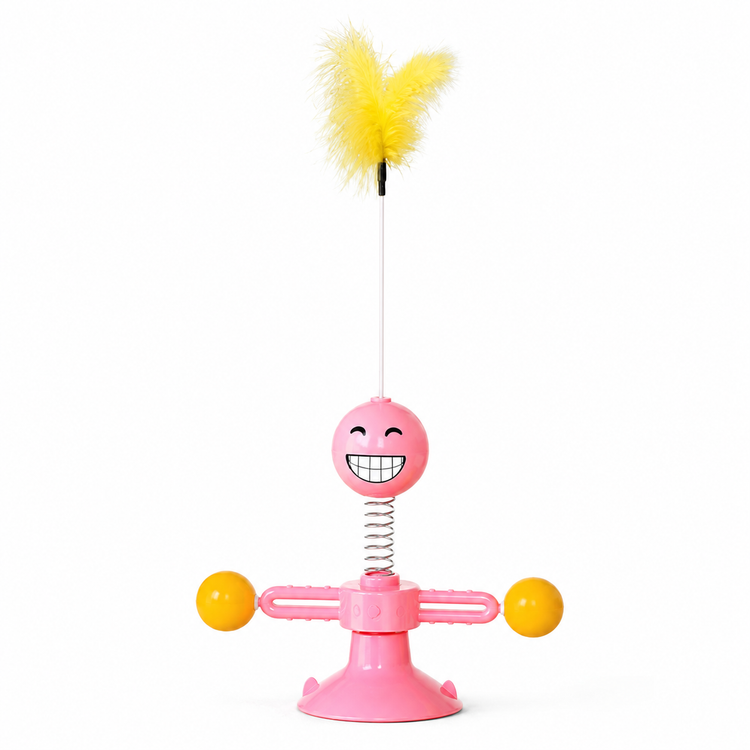Pink toy with a smiling face, yellow balls, and a yellow feather on a white background
