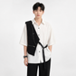 Person wearing a white shirt with a black vest and black pants on a white background