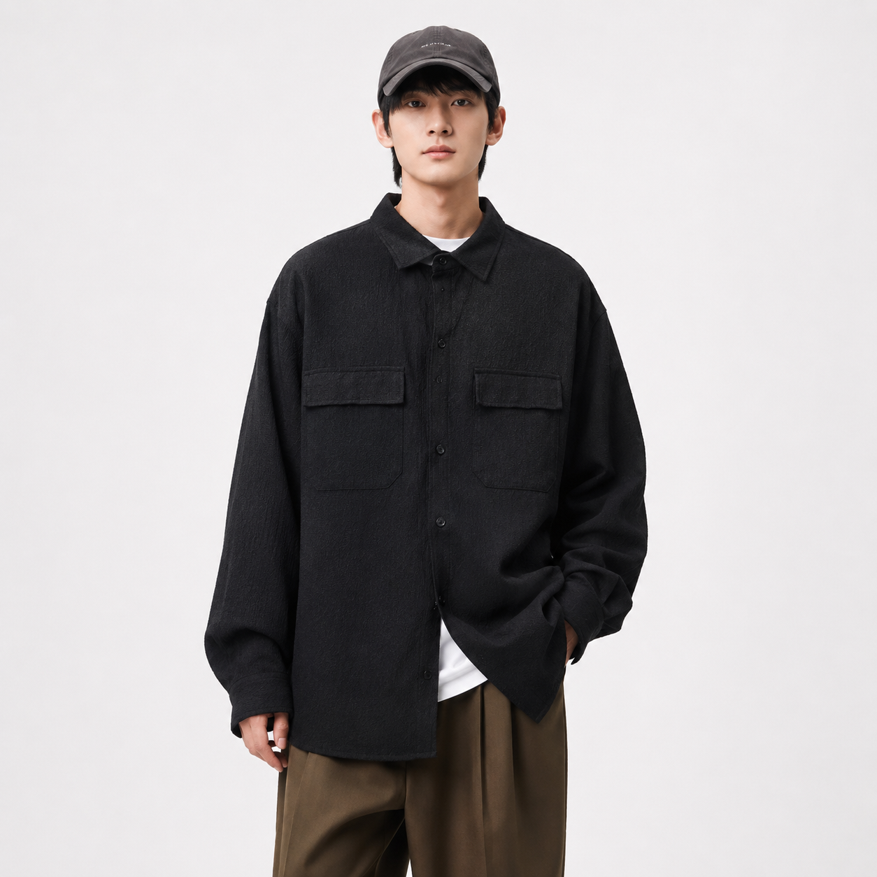 Person wearing a black jacket and brown pants on a white background