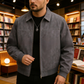 Man wearing a gray jacket in a bookstore setting
