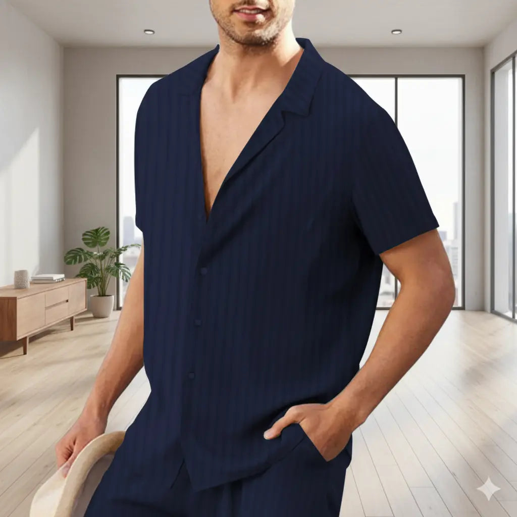 man in navy blue striped short-sleeve shirt holding hat and standing in bright room