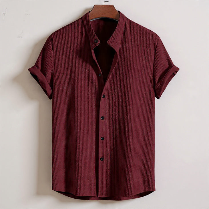Maroon textured shirt on a hanger against a white background