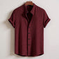 Maroon textured shirt on a hanger against a white background
