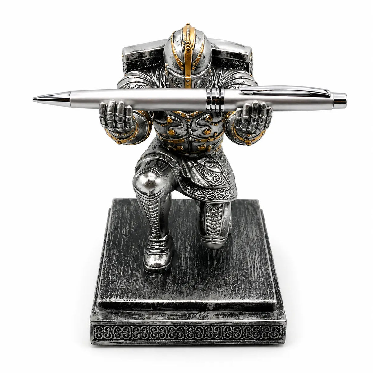 Medieval knight pen holder in silver and gold armor, kneeling pose with a pen held horizontally on a textured base.