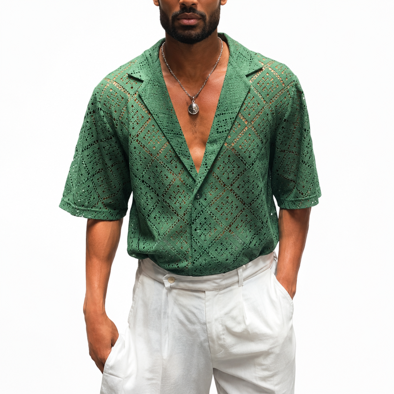 Man wearing a green patterned shirt and white pants on a white background