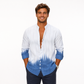 Man wearing a white and blue tie-dye shirt with rolled-up sleeves on a white background