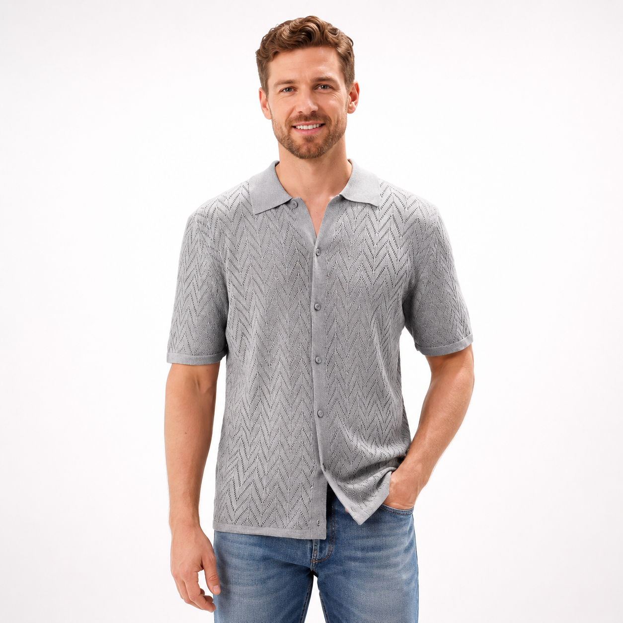 Man wearing a gray patterned shirt and blue jeans on a white background
