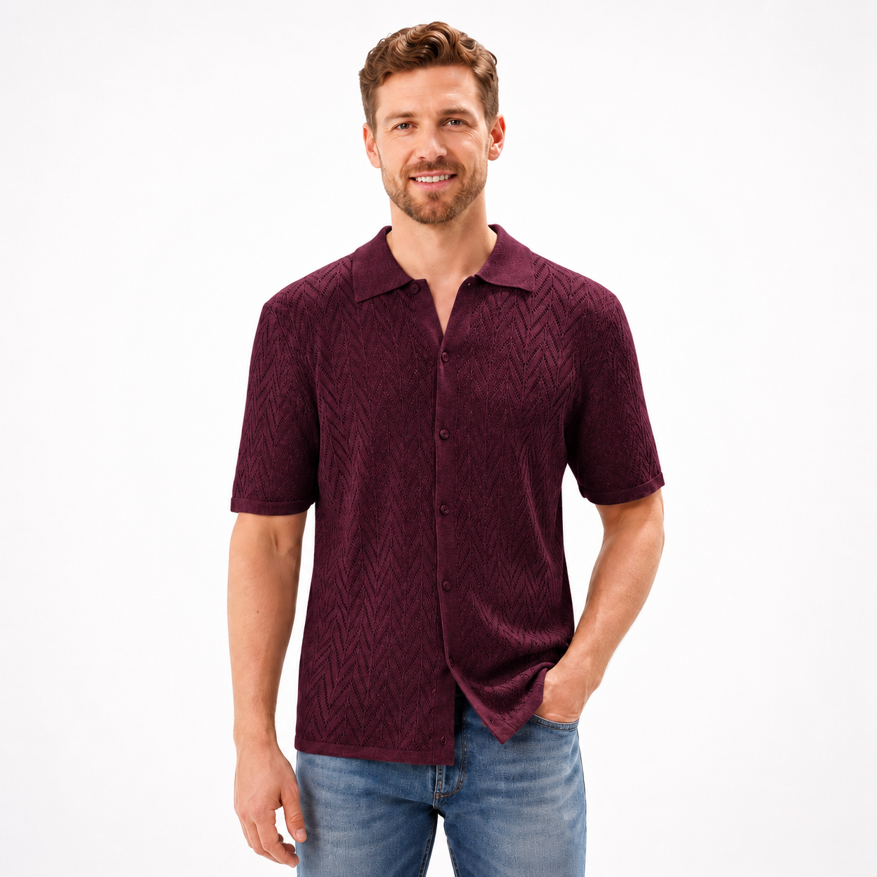 Man wearing a maroon patterned shirt and blue jeans on a white background