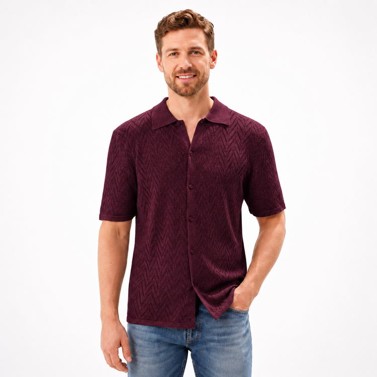 Man wearing a maroon patterned shirt and blue jeans on a white background