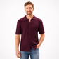 Man wearing a maroon patterned shirt and blue jeans on a white background