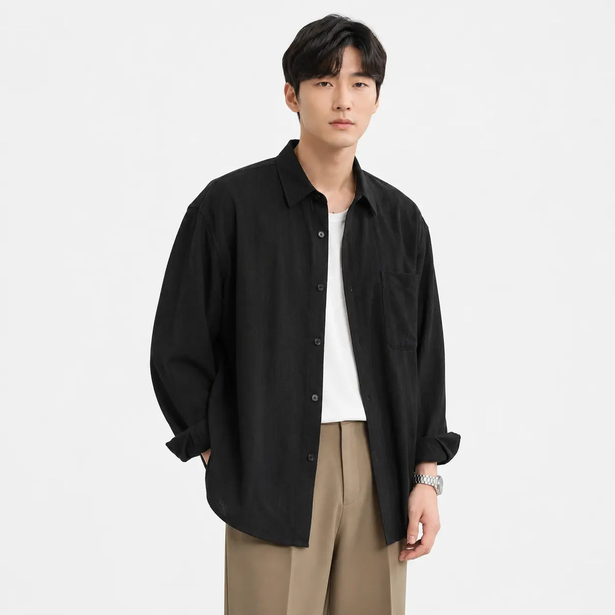 Men's linen shirt - loose fit long sleeve solid color button up in black worn by a model with rolled sleeves.