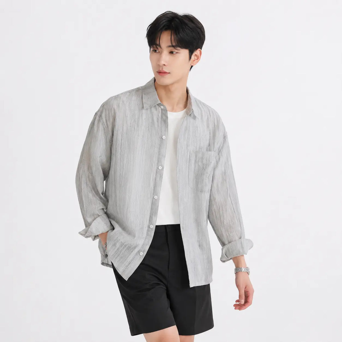 Men's linen shirt - loose fit long sleeve solid color button up in light gray worn by a model with rolled sleeves.