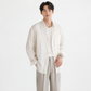 Man wearing a white shirt and beige pants on a white background