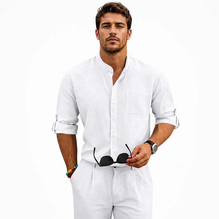 Man wearing a white shirt and pants holding sunglasses on a white background