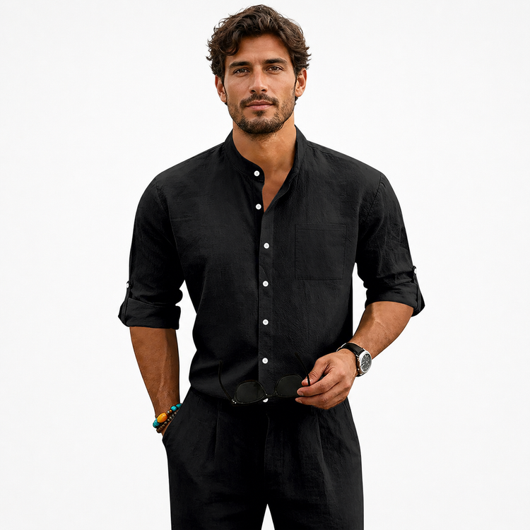 Man wearing a black button-up shirt and black pants on a white background