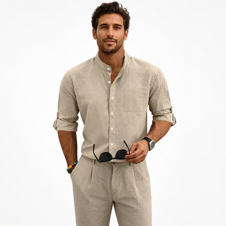 Man wearing a beige shirt and pants with sunglasses on a white background